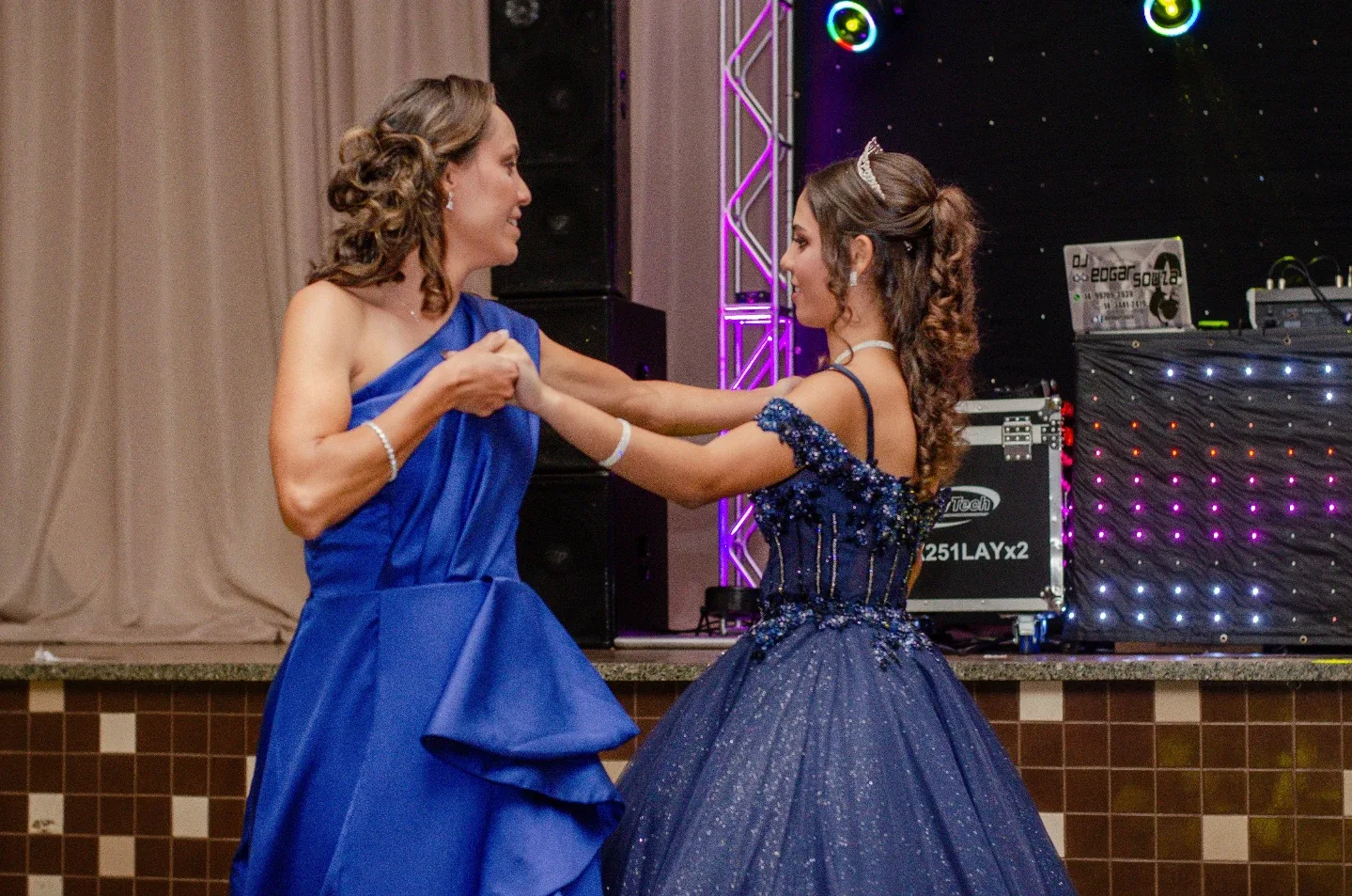 Duas mulheres de vestido azul dançando durante uma festa.
