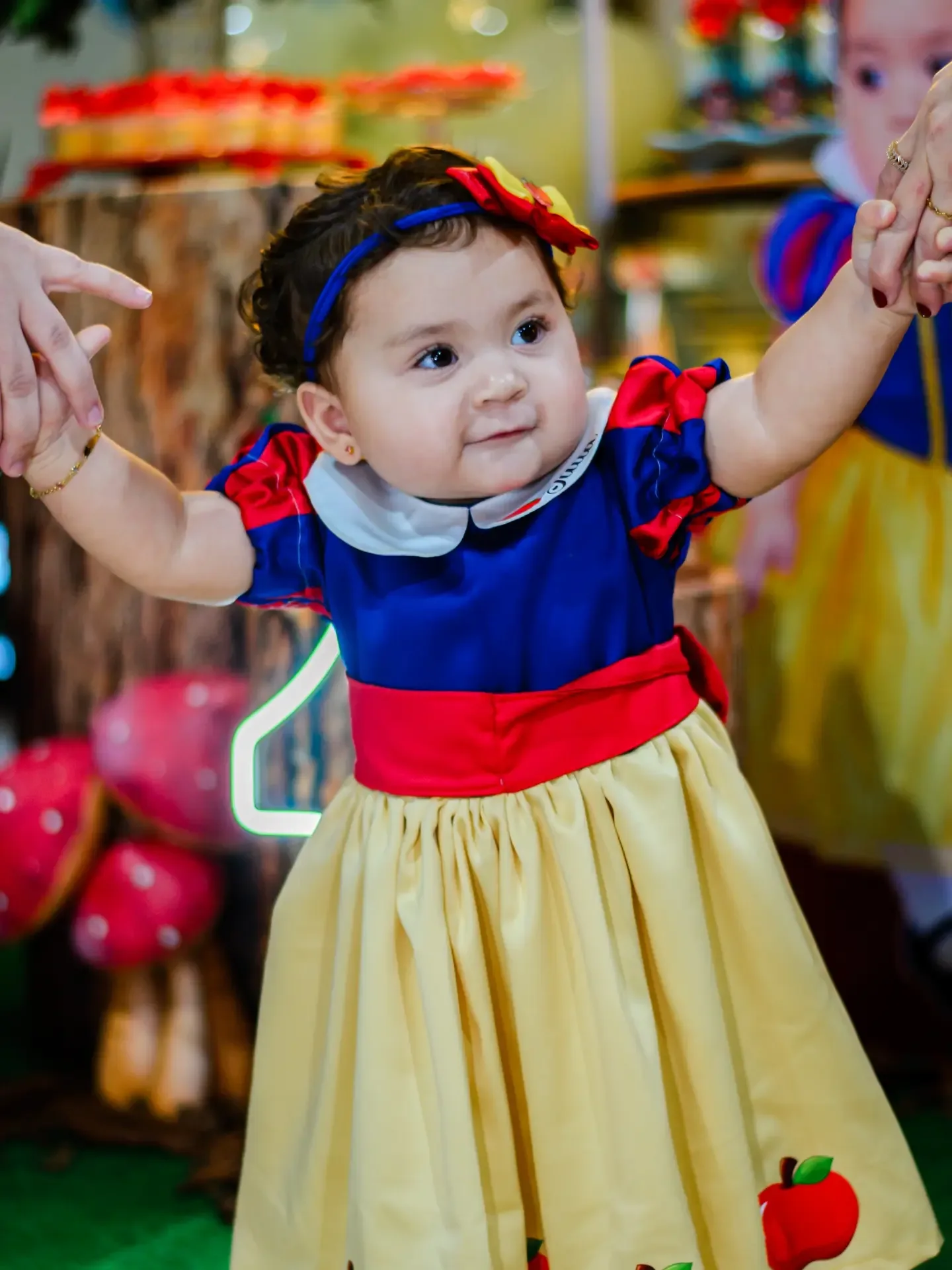 Criança com vestido colorido em festa de aniversário.