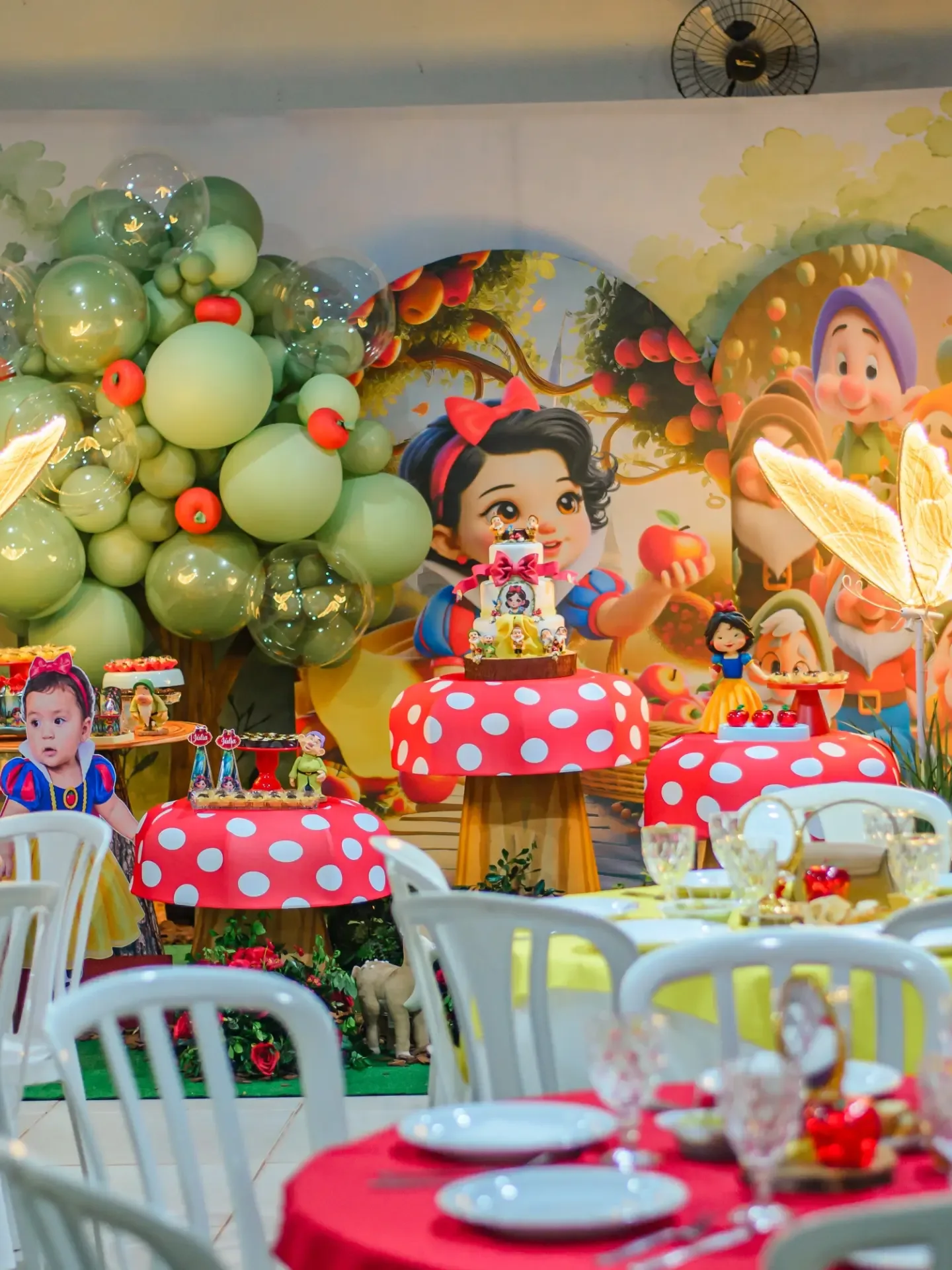 Mesa de aniversário com bolo, doces e decoração colorida.