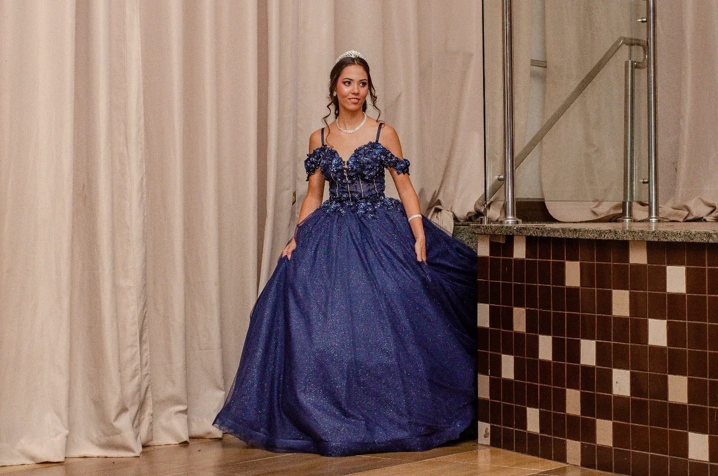 Mulher com vestido azul em salão de eventos.