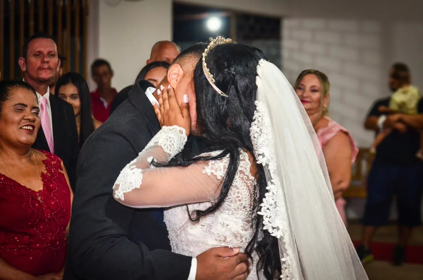 Casal se beijando durante cerimônia de casamento.