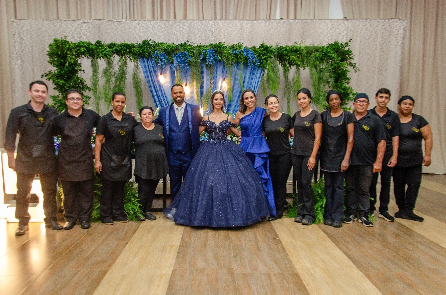Grupo reunido para fotografia diante da decoração de uma festa.