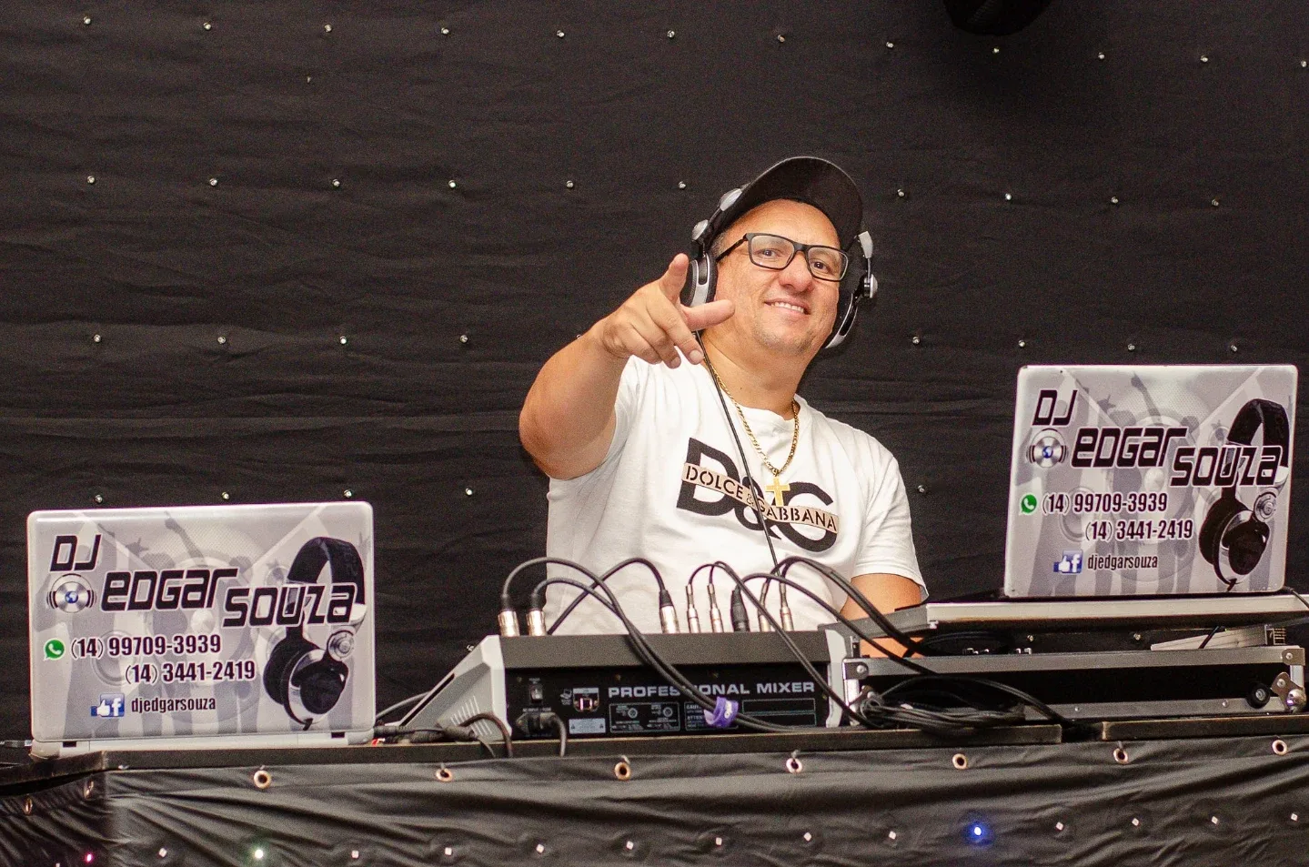 DJ diante de equipamentos de som durante um evento.
