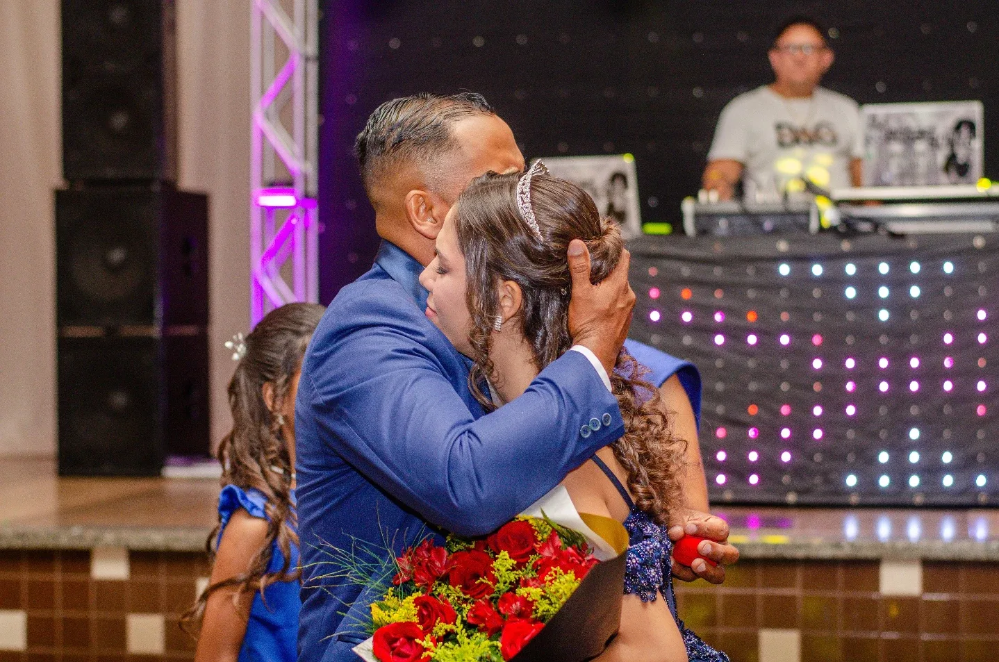 Duas pessoas abraçadas durante uma festa.