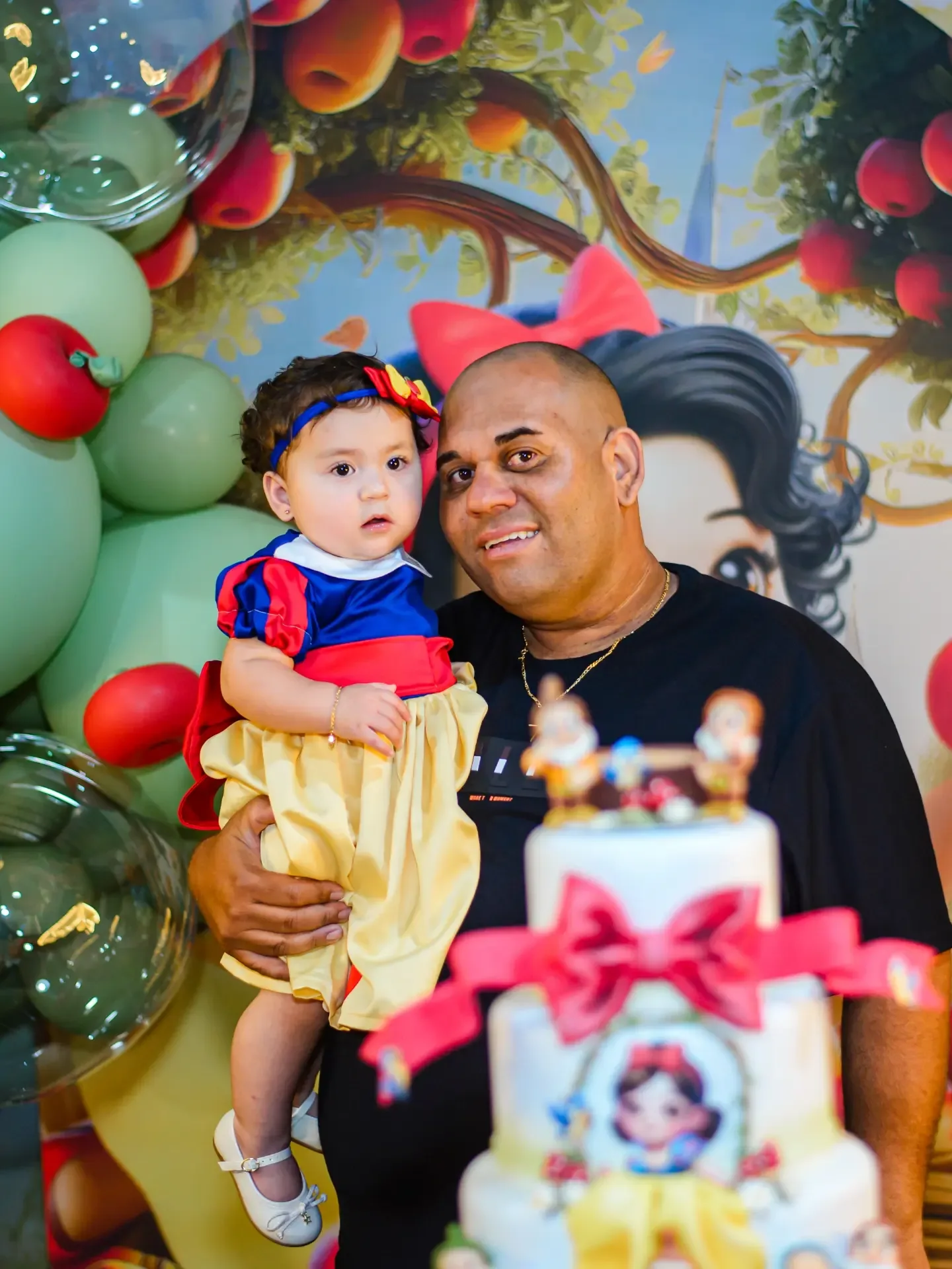 Criança e adulto diante de decoração de aniversário.