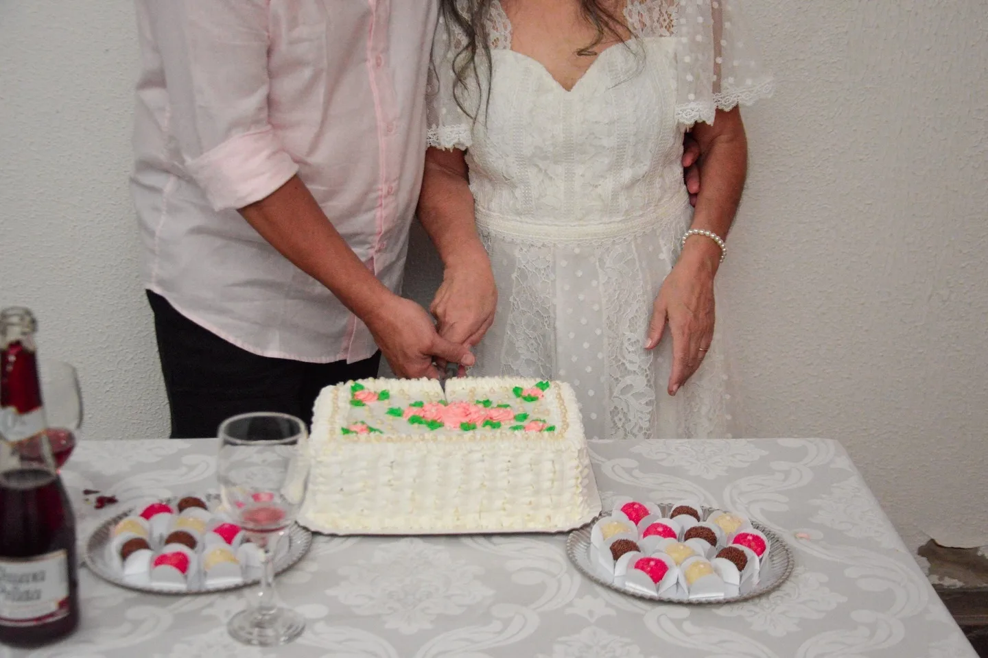 Detalhe do casal e do bolo em uma celebração de casamento.